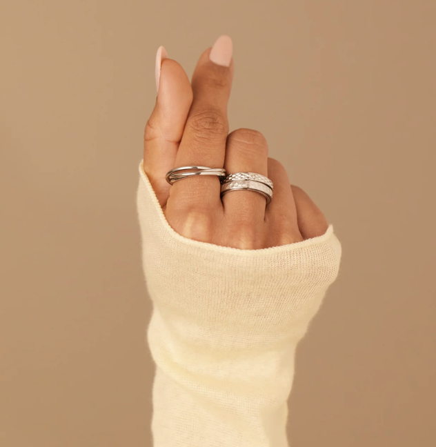 Woman's hand shows multiple rings in silver